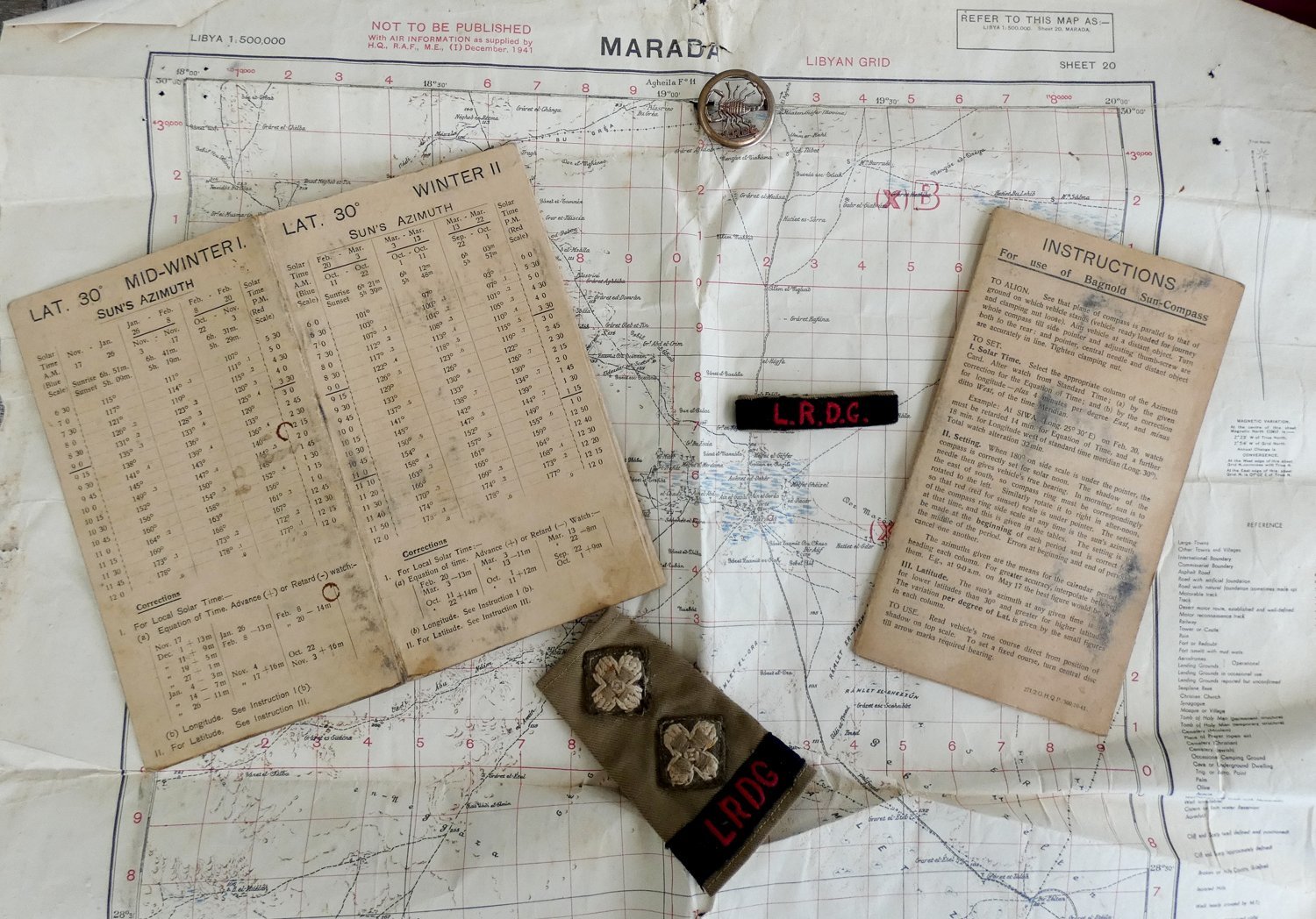 Bagnold sun-compass azimuth cards and instructions laid on a Libyan map with LRDG insignia
