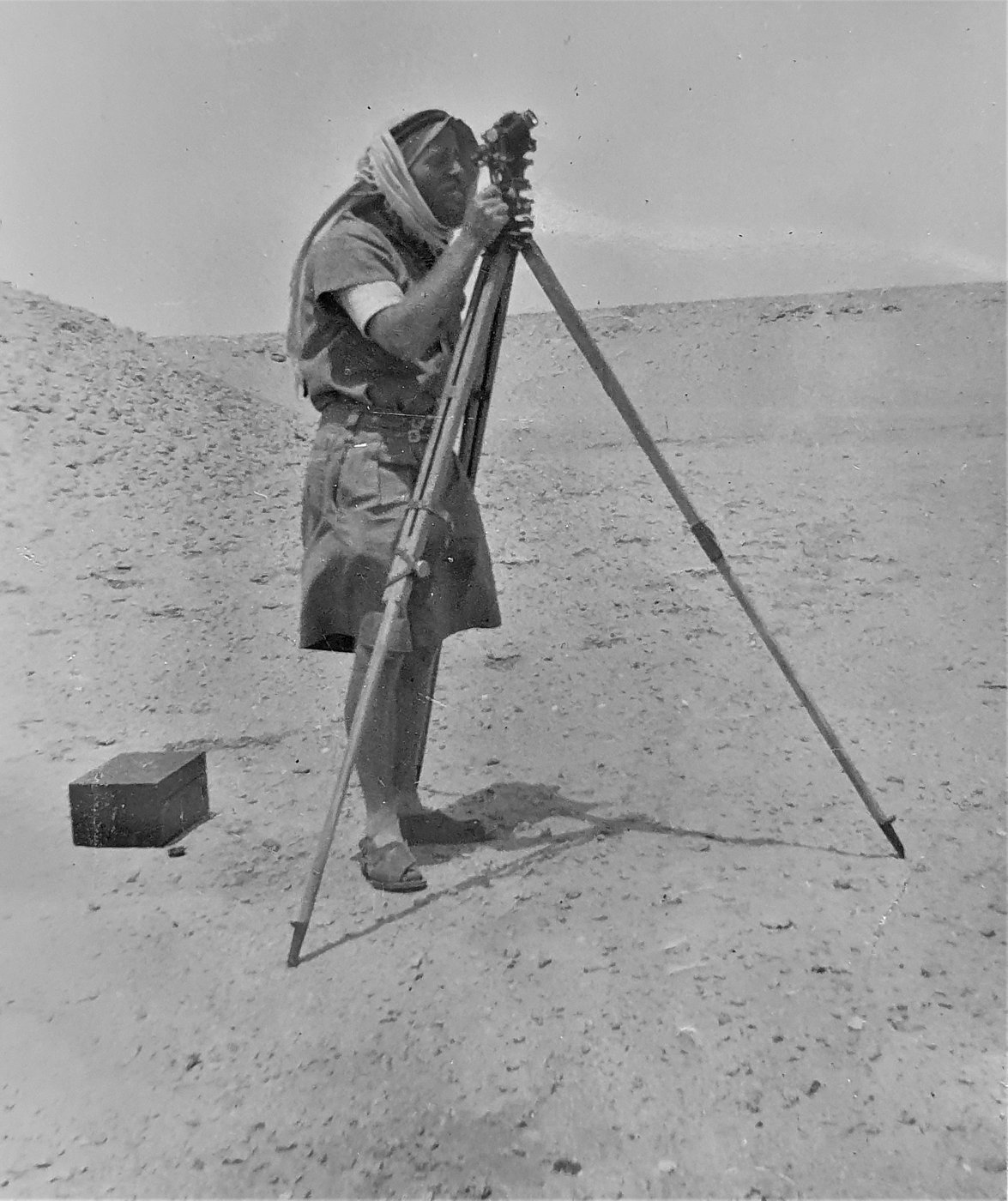 R Patrol navigator Bluey Grimsey taking a theodolite sight in the desert